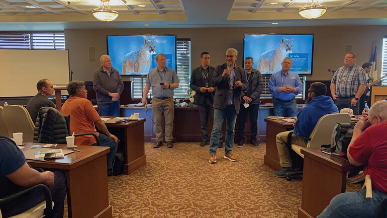 Men standing and speaking in a seminar.