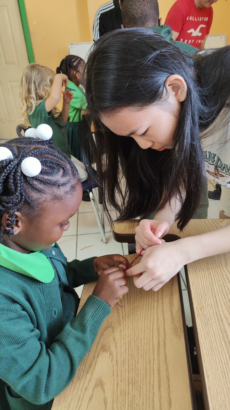 teenage girl helping young girl with project