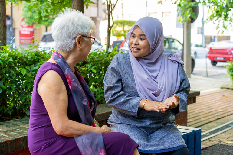 Multi-racial friends having a heart to heart conversation outdoors.