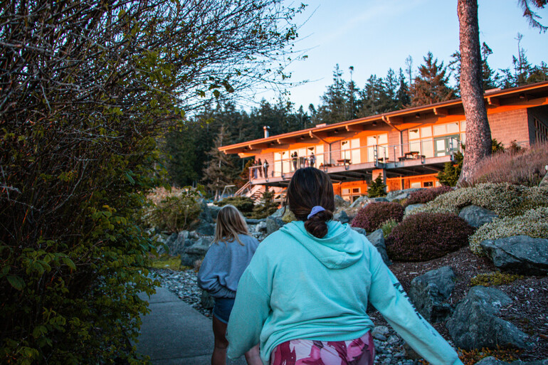 Students walk toward beachside building.