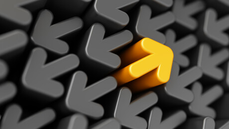 One yellow arrow pointing back in a sea of grey arrows pointing in the opposite direction.