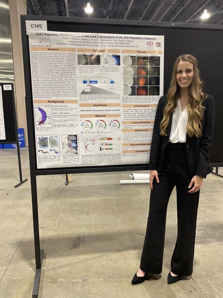 Young woman standing by scientific poster.