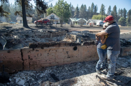 Couple embraces each other after losing their home in the Babb Road Fire.