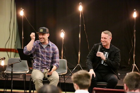 two men sitting on stage with microphones