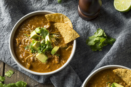 Spicy Homemade Tortilla Soup with Cheese Cilantro and Lime