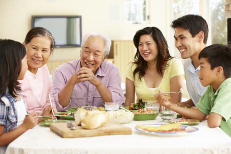 Asian family sharing meal at home looking a teen girl