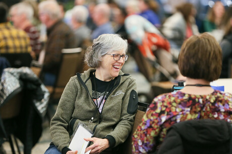 woman laughs surrounded by other people