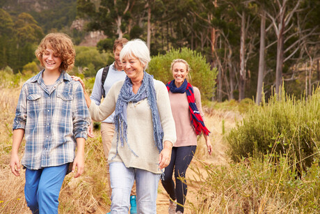 Family with grandmother walking through a forest together