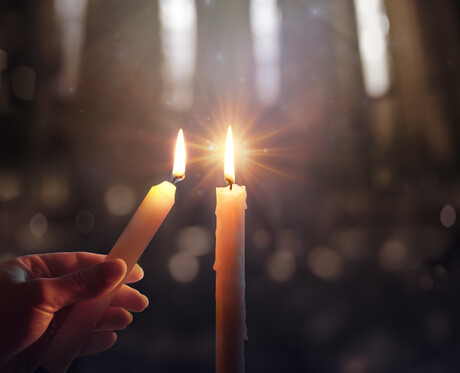 Sharing Concept - Hands Holding Candle With Shining Flame And Blurry Lights
