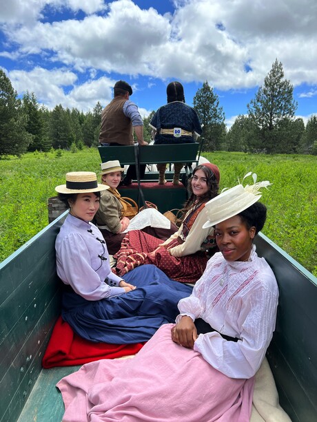 Color of Threads actors on set in a wagon.