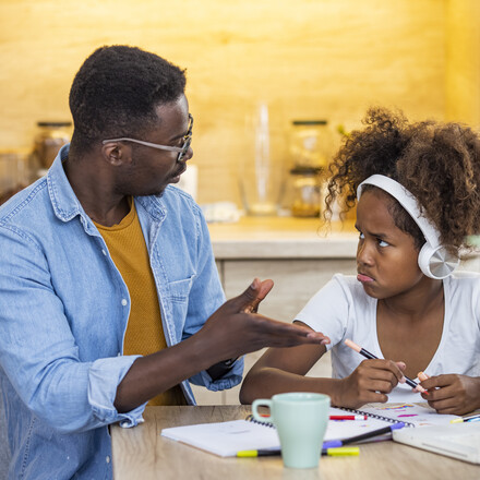 Father talking to pouting daughter.