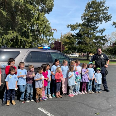 All Nations Center Adventurer Club takes a photo with a local police officer.