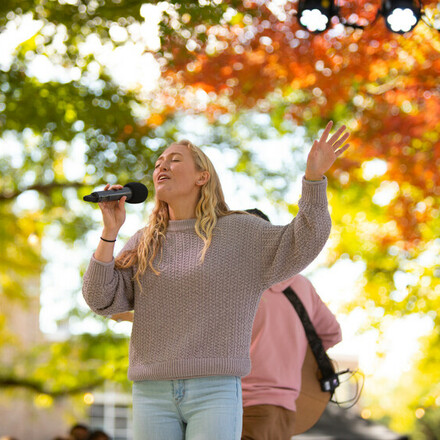 Student sings on outdoor stage
