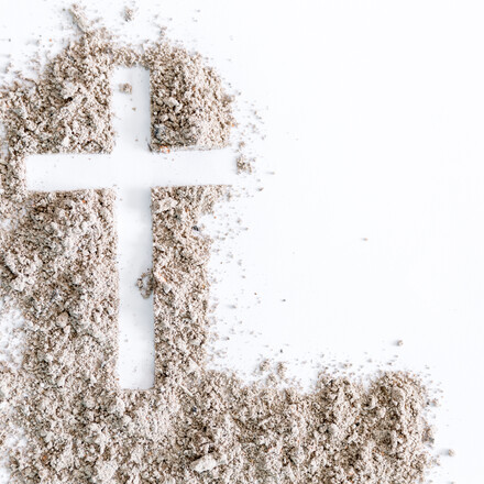 Christian cross or crucifix drawing in ash, dust or sand as symbol of religion, sacrifice, redemption, Jesus Christ, ash wednesday, lent, Good Friday, Easter with Church is devoted to fasting