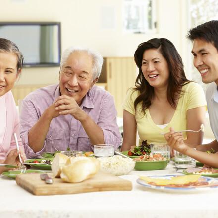 Asian family sharing meal at home looking a teen girl