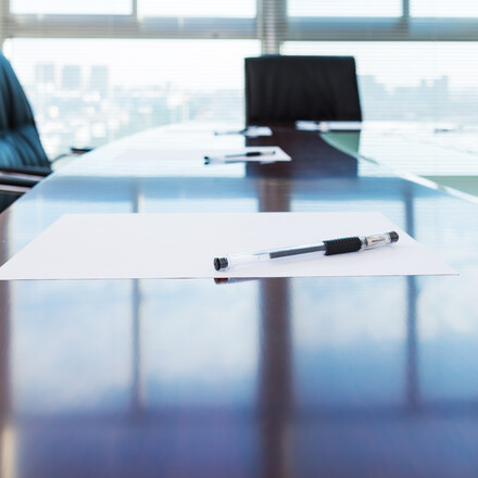 Corporate boardroom with blank paper set for the meeting.