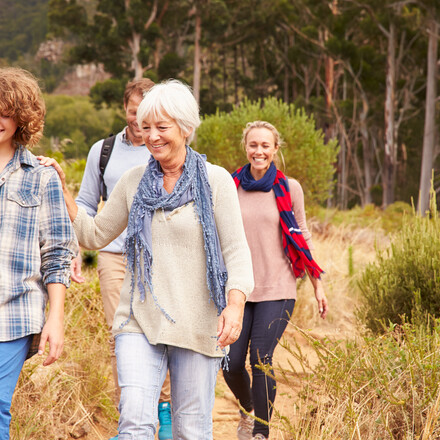 Family with grandmother walking through a forest together
