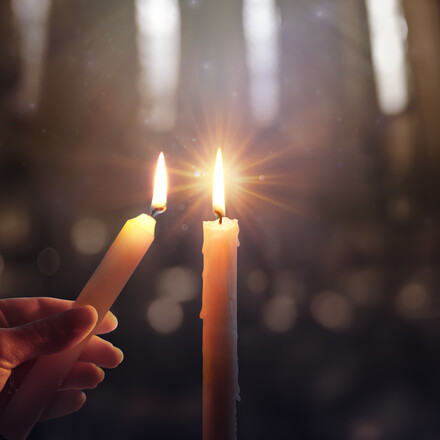 Sharing Concept - Hands Holding Candle With Shining Flame And Blurry Lights