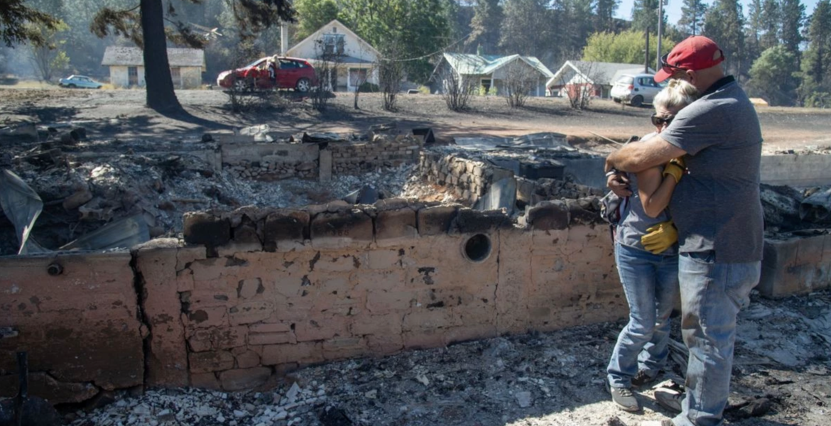 Couple embraces each other after losing their home in the Babb Road Fire.